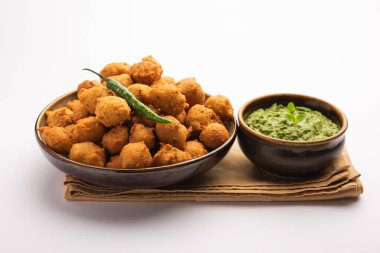 Muson Özel Moong Dal Vada, Pakoda, Dalwada, Pakora veya Mungdal Bhajiya veya Yeşil Chutney ile servis edilen Sarı Börek. seçici odak