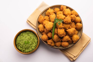 Muson Özel Moong Dal Vada, Pakoda, Dalwada, Pakora veya Mungdal Bhajiya veya Yeşil Chutney ile servis edilen Sarı Börek. seçici odak