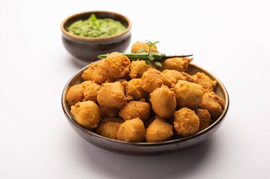 Muson Özel Moong Dal Vada, Pakoda, Dalwada, Pakora veya Mungdal Bhajiya veya Yeşil Chutney ile servis edilen Sarı Börek. seçici odak