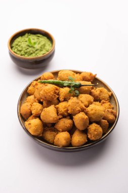 Muson Özel Moong Dal Vada, Pakoda, Dalwada, Pakora veya Mungdal Bhajiya veya Yeşil Chutney ile servis edilen Sarı Börek. seçici odak