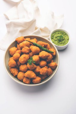 Muson Özel Moong Dal Vada, Pakoda, Dalwada, Pakora veya Mungdal Bhajiya veya Yeşil Chutney ile servis edilen Sarı Börek. seçici odak