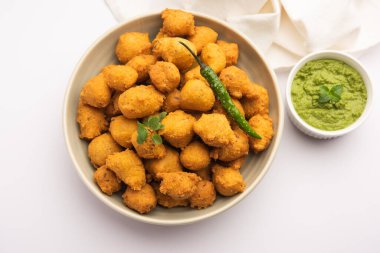 Muson Özel Moong Dal Vada, Pakoda, Dalwada, Pakora veya Mungdal Bhajiya veya Yeşil Chutney ile servis edilen Sarı Börek. seçici odak