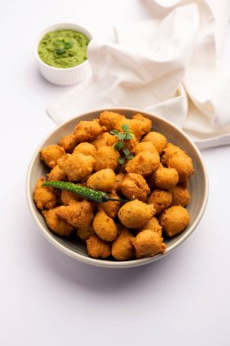 Muson Özel Moong Dal Vada, Pakoda, Dalwada, Pakora veya Mungdal Bhajiya veya Yeşil Chutney ile servis edilen Sarı Börek. seçici odak