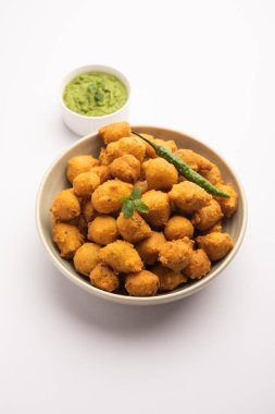 Muson Özel Moong Dal Vada, Pakoda, Dalwada, Pakora veya Mungdal Bhajiya veya Yeşil Chutney ile servis edilen Sarı Börek. seçici odak
