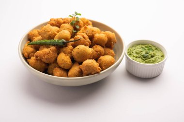 Muson Özel Moong Dal Vada, Pakoda, Dalwada, Pakora veya Mungdal Bhajiya veya Yeşil Chutney ile servis edilen Sarı Börek. seçici odak