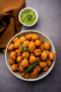 Muson Özel Moong Dal Vada, Pakoda, Dalwada, Pakora veya Mungdal Bhajiya veya Yeşil Chutney ile servis edilen Sarı Börek. seçici odak