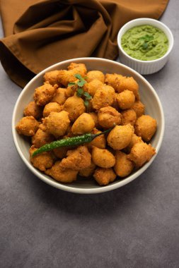 Muson Özel Moong Dal Vada, Pakoda, Dalwada, Pakora veya Mungdal Bhajiya veya Yeşil Chutney ile servis edilen Sarı Börek. seçici odak