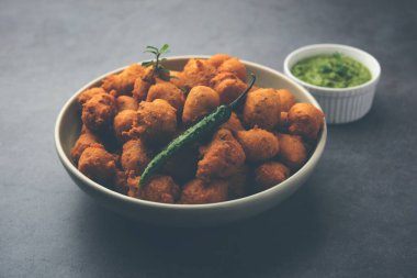 Muson Özel Moong Dal Vada, Pakoda, Dalwada, Pakora veya Mungdal Bhajiya veya Yeşil Chutney ile servis edilen Sarı Börek. seçici odak