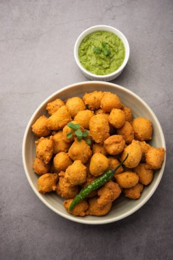 Muson Özel Moong Dal Vada, Pakoda, Dalwada, Pakora veya Mungdal Bhajiya veya Yeşil Chutney ile servis edilen Sarı Börek. seçici odak