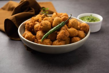 Muson Özel Moong Dal Vada, Pakoda, Dalwada, Pakora veya Mungdal Bhajiya veya Yeşil Chutney ile servis edilen Sarı Börek. seçici odak