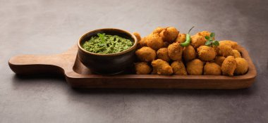 Muson Özel Moong Dal Vada, Pakoda, Dalwada, Pakora veya Mungdal Bhajiya veya Yeşil Chutney ile servis edilen Sarı Börek. seçici odak