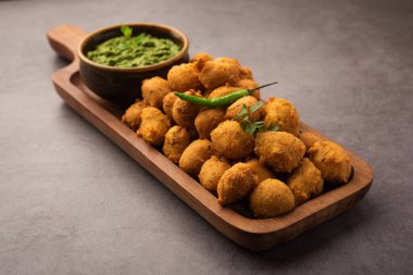 Muson Özel Moong Dal Vada, Pakoda, Dalwada, Pakora veya Mungdal Bhajiya veya Yeşil Chutney ile servis edilen Sarı Börek. seçici odak