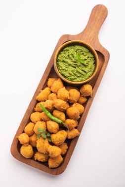 Muson Özel Moong Dal Vada, Pakoda, Dalwada, Pakora veya Mungdal Bhajiya veya Yeşil Chutney ile servis edilen Sarı Börek. seçici odak