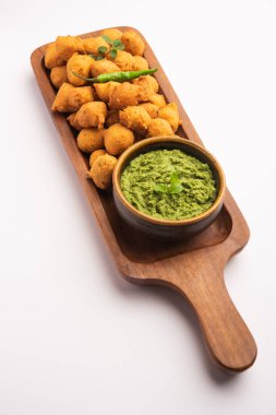 Muson Özel Moong Dal Vada, Pakoda, Dalwada, Pakora veya Mungdal Bhajiya veya Yeşil Chutney ile servis edilen Sarı Börek. seçici odak