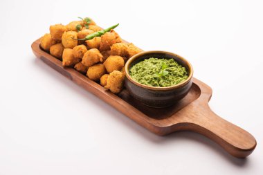 Muson Özel Moong Dal Vada, Pakoda, Dalwada, Pakora veya Mungdal Bhajiya veya Yeşil Chutney ile servis edilen Sarı Börek. seçici odak