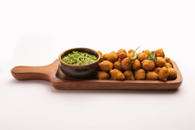 Muson Özel Moong Dal Vada, Pakoda, Dalwada, Pakora veya Mungdal Bhajiya veya Yeşil Chutney ile servis edilen Sarı Börek. seçici odak