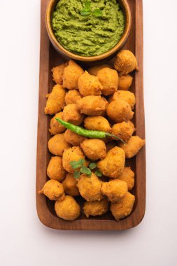 Muson Özel Moong Dal Vada, Pakoda, Dalwada, Pakora veya Mungdal Bhajiya veya Yeşil Chutney ile servis edilen Sarı Börek. seçici odak