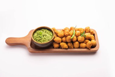 Muson Özel Moong Dal Vada, Pakoda, Dalwada, Pakora veya Mungdal Bhajiya veya Yeşil Chutney ile servis edilen Sarı Börek. seçici odak