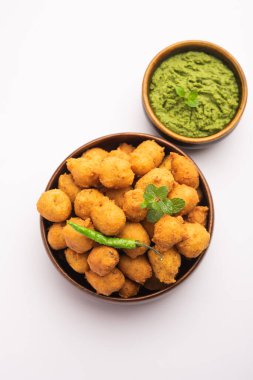 Muson Özel Moong Dal Vada, Pakoda, Dalwada, Pakora veya Mungdal Bhajiya veya Yeşil Chutney ile servis edilen Sarı Börek. seçici odak