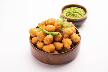 Muson Özel Moong Dal Vada, Pakoda, Dalwada, Pakora veya Mungdal Bhajiya veya Yeşil Chutney ile servis edilen Sarı Börek. seçici odak