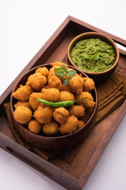 Muson Özel Moong Dal Vada, Pakoda, Dalwada, Pakora veya Mungdal Bhajiya veya Yeşil Chutney ile servis edilen Sarı Börek. seçici odak