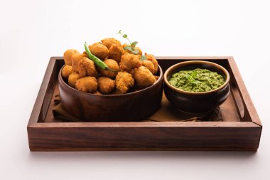 Muson Özel Moong Dal Vada, Pakoda, Dalwada, Pakora veya Mungdal Bhajiya veya Yeşil Chutney ile servis edilen Sarı Börek. seçici odak