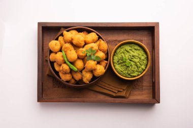 Muson Özel Moong Dal Vada, Pakoda, Dalwada, Pakora veya Mungdal Bhajiya veya Yeşil Chutney ile servis edilen Sarı Börek. seçici odak