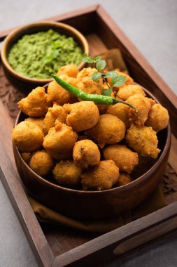 Muson Özel Moong Dal Vada, Pakoda, Dalwada, Pakora veya Mungdal Bhajiya veya Yeşil Chutney ile servis edilen Sarı Börek. seçici odak