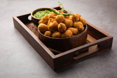 Muson Özel Moong Dal Vada, Pakoda, Dalwada, Pakora veya Mungdal Bhajiya veya Yeşil Chutney ile servis edilen Sarı Börek. seçici odak