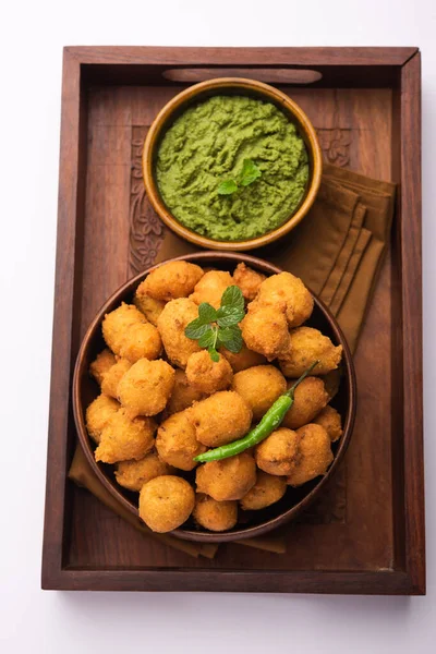 Muson Özel Moong Dal Vada, Pakoda, Dalwada, Pakora veya Mungdal Bhajiya veya Yeşil Chutney ile servis edilen Sarı Börek. seçici odak