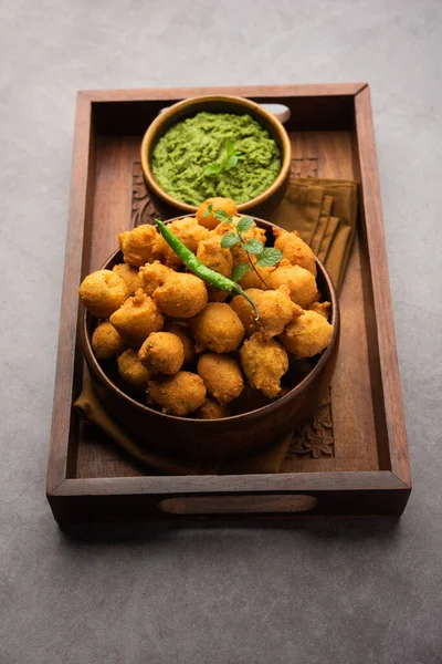 Muson Özel Moong Dal Vada, Pakoda, Dalwada, Pakora veya Mungdal Bhajiya veya Yeşil Chutney ile servis edilen Sarı Börek. seçici odak