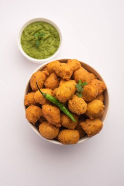 Muson Özel Moong Dal Vada, Pakoda, Dalwada, Pakora veya Mungdal Bhajiya veya Yeşil Chutney ile servis edilen Sarı Börek. seçici odak