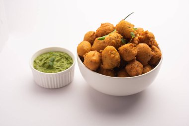 Muson Özel Moong Dal Vada, Pakoda, Dalwada, Pakora veya Mungdal Bhajiya veya Yeşil Chutney ile servis edilen Sarı Börek. seçici odak