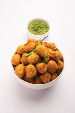Muson Özel Moong Dal Vada, Pakoda, Dalwada, Pakora veya Mungdal Bhajiya veya Yeşil Chutney ile servis edilen Sarı Börek. seçici odak
