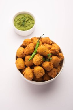 Muson Özel Moong Dal Vada, Pakoda, Dalwada, Pakora veya Mungdal Bhajiya veya Yeşil Chutney ile servis edilen Sarı Börek. seçici odak