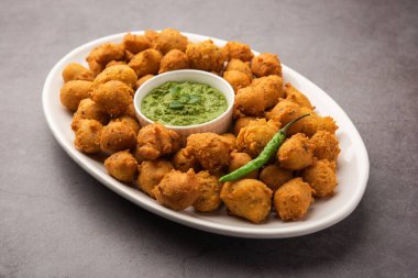 Muson Özel Moong Dal Vada, Pakoda, Dalwada, Pakora veya Mungdal Bhajiya veya Yeşil Chutney ile servis edilen Sarı Börek. seçici odak