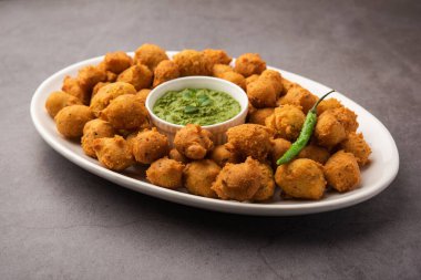 Muson Özel Moong Dal Vada, Pakoda, Dalwada, Pakora veya Mungdal Bhajiya veya Yeşil Chutney ile servis edilen Sarı Börek. seçici odak