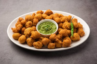 Muson Özel Moong Dal Vada, Pakoda, Dalwada, Pakora veya Mungdal Bhajiya veya Yeşil Chutney ile servis edilen Sarı Börek. seçici odak