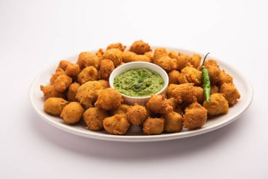 Muson Özel Moong Dal Vada, Pakoda, Dalwada, Pakora veya Mungdal Bhajiya veya Yeşil Chutney ile servis edilen Sarı Börek. seçici odak