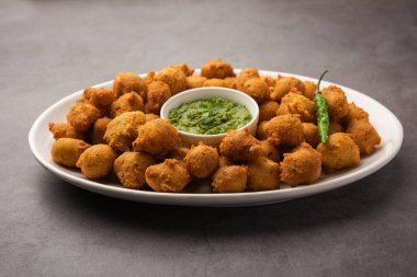 Muson Özel Moong Dal Vada, Pakoda, Dalwada, Pakora veya Mungdal Bhajiya veya Yeşil Chutney ile servis edilen Sarı Börek. seçici odak