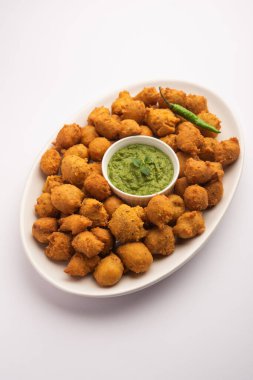 Muson Özel Moong Dal Vada, Pakoda, Dalwada, Pakora veya Mungdal Bhajiya veya Yeşil Chutney ile servis edilen Sarı Börek. seçici odak