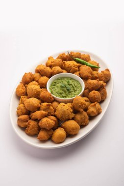 Muson Özel Moong Dal Vada, Pakoda, Dalwada, Pakora veya Mungdal Bhajiya veya Yeşil Chutney ile servis edilen Sarı Börek. seçici odak