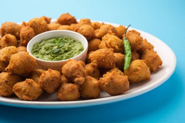 Muson Özel Moong Dal Vada, Pakoda, Dalwada, Pakora veya Mungdal Bhajiya veya Yeşil Chutney ile servis edilen Sarı Börek. seçici odak