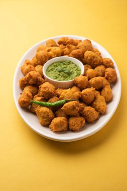 Muson Özel Moong Dal Vada, Pakoda, Dalwada, Pakora veya Mungdal Bhajiya veya Yeşil Chutney ile servis edilen Sarı Börek. seçici odak