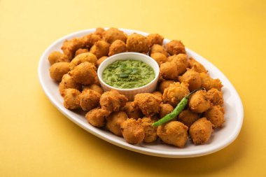 Muson Özel Moong Dal Vada, Pakoda, Dalwada, Pakora veya Mungdal Bhajiya veya Yeşil Chutney ile servis edilen Sarı Börek. seçici odak