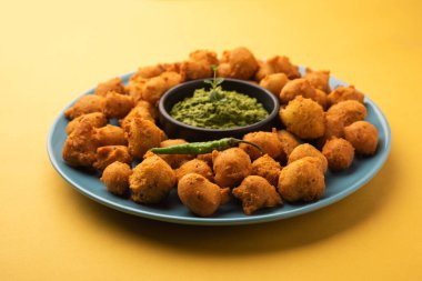 Muson Özel Moong Dal Vada, Pakoda, Dalwada, Pakora veya Mungdal Bhajiya veya Yeşil Chutney ile servis edilen Sarı Börek. seçici odak