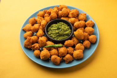 Muson Özel Moong Dal Vada, Pakoda, Dalwada, Pakora veya Mungdal Bhajiya veya Yeşil Chutney ile servis edilen Sarı Börek. seçici odak