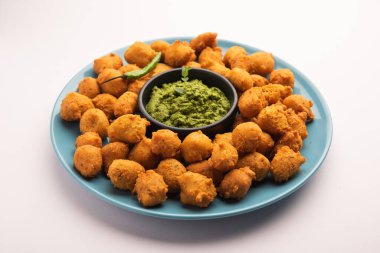 Muson Özel Moong Dal Vada, Pakoda, Dalwada, Pakora veya Mungdal Bhajiya veya Yeşil Chutney ile servis edilen Sarı Börek. seçici odak