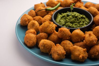 Muson Özel Moong Dal Vada, Pakoda, Dalwada, Pakora veya Mungdal Bhajiya veya Yeşil Chutney ile servis edilen Sarı Börek. seçici odak