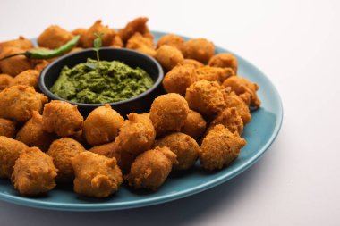 Muson Özel Moong Dal Vada, Pakoda, Dalwada, Pakora veya Mungdal Bhajiya veya Yeşil Chutney ile servis edilen Sarı Börek. seçici odak